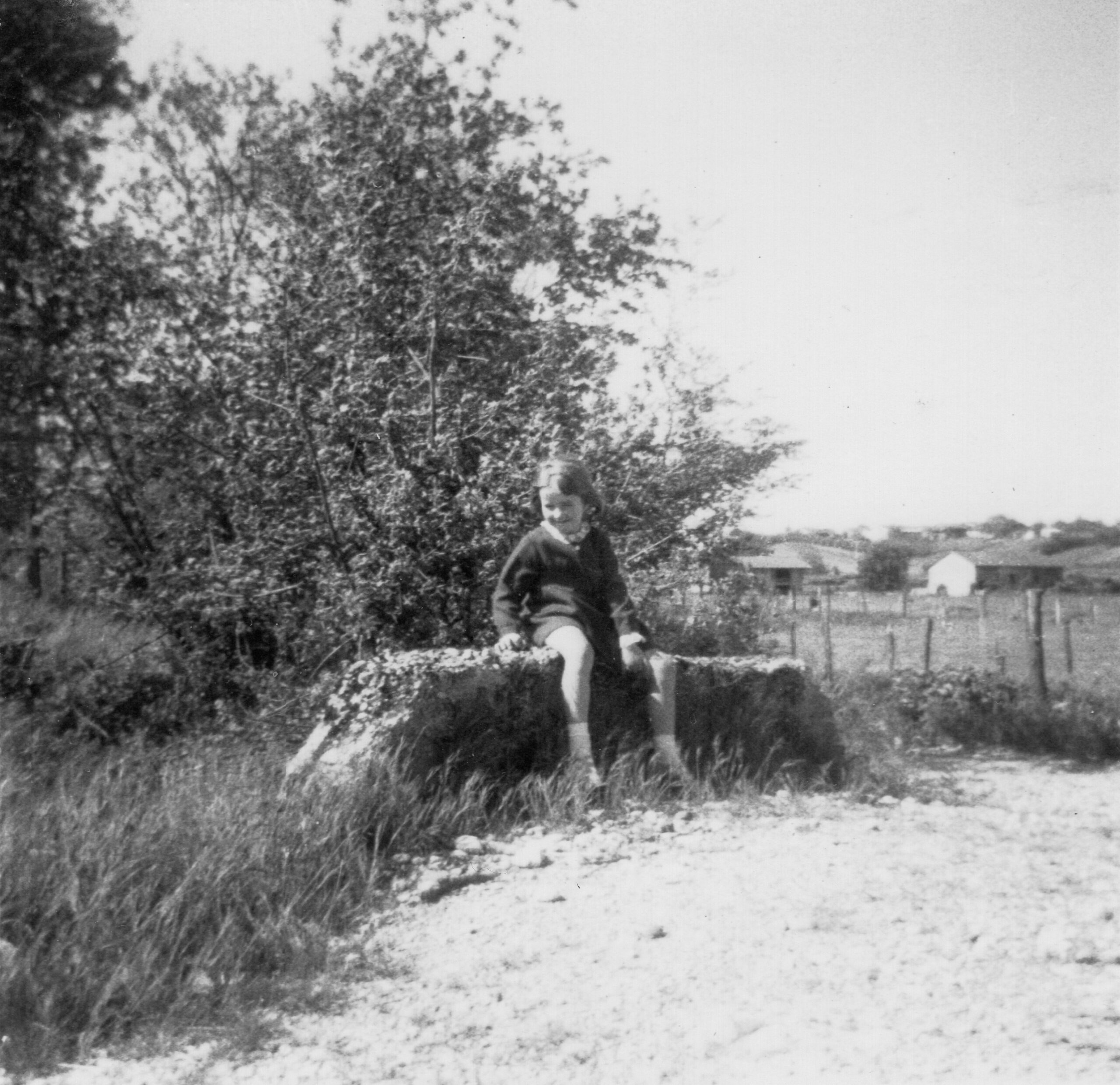 Beatrice Venard assise sur un banc, dans un jardin